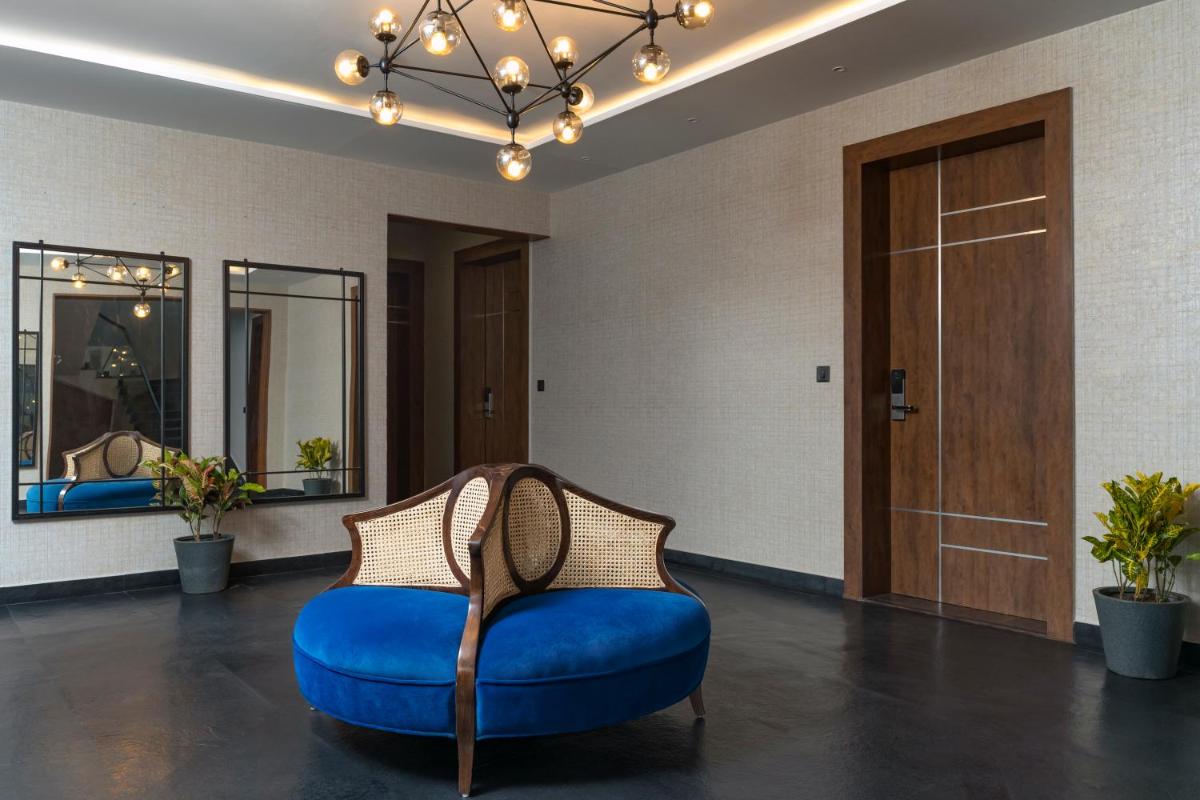 a room with a blue couch and mirrors at ZANA Lakeview Resort - most scenic lakeside resort in Udaipur