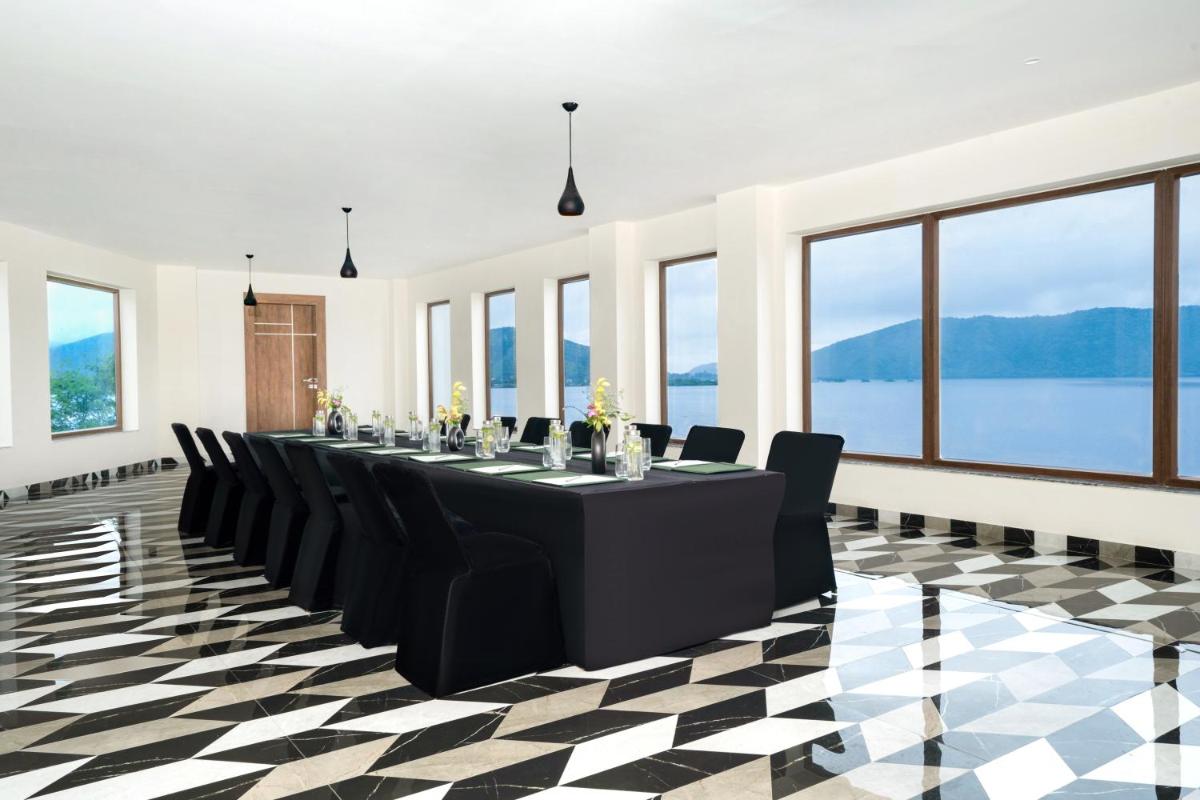 a conference room with a long table and black chairs at ZANA Lakeview Resort - most scenic lakeside resort in Udaipur