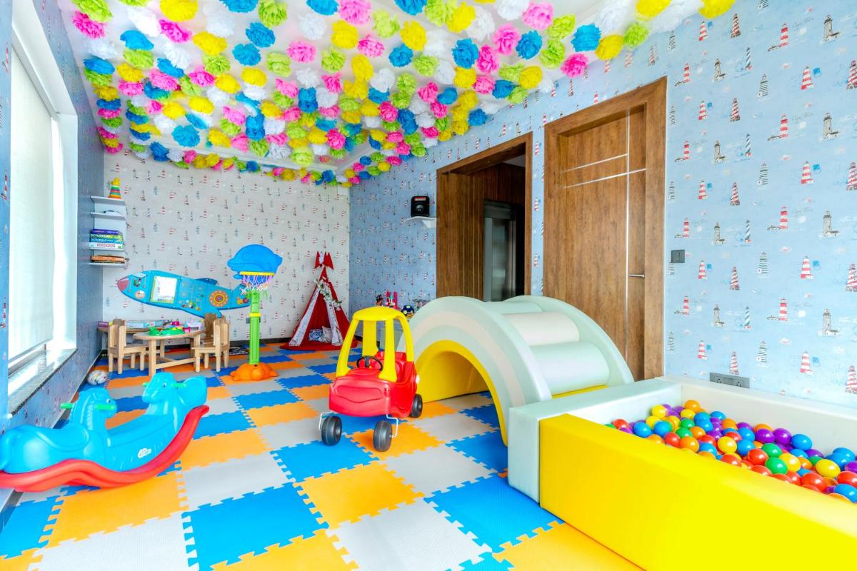 a childs room with a playroom with toys and a slide at ZANA Lakeview Resort - most scenic lakeside resort in Udaipur