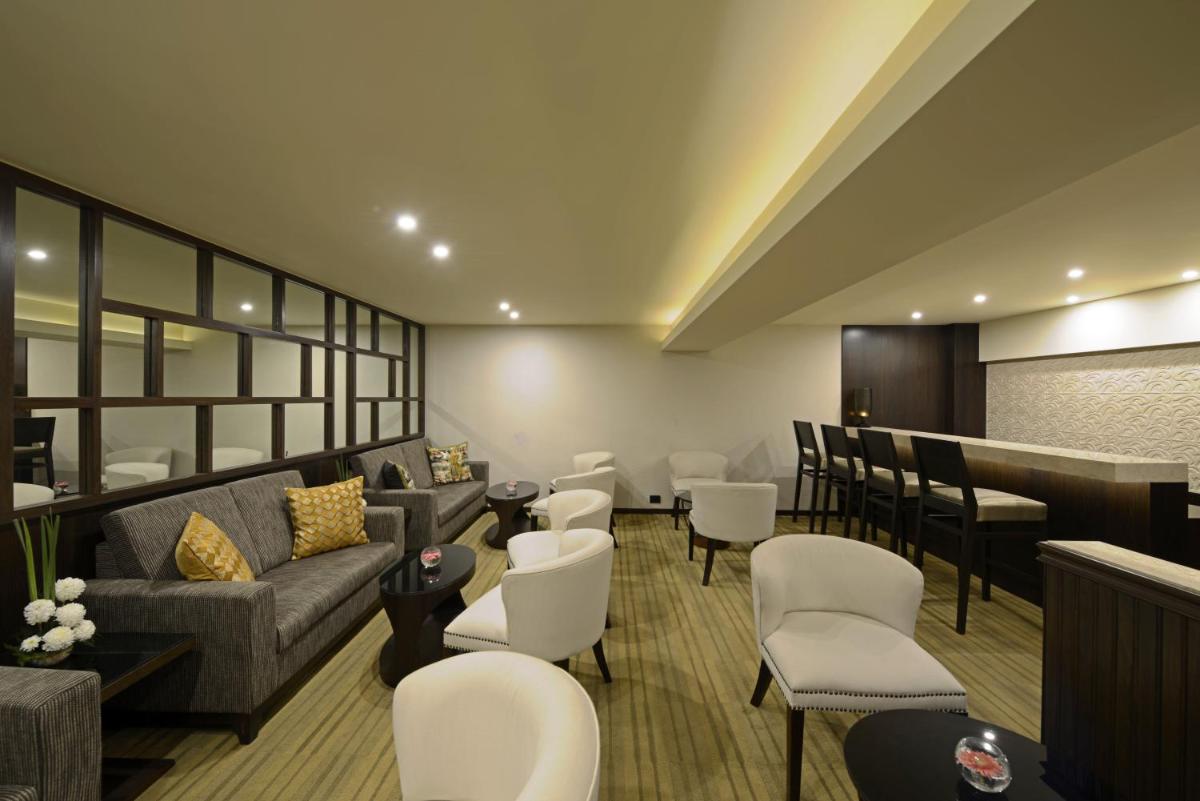 a waiting room with couches and chairs and a bar at Sun-n-Sand Mumbai Juhu Beach in Mumbai