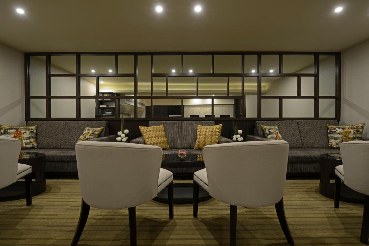 a living room with a couch and a table and chairs at Sun-n-Sand Mumbai Juhu Beach in Mumbai