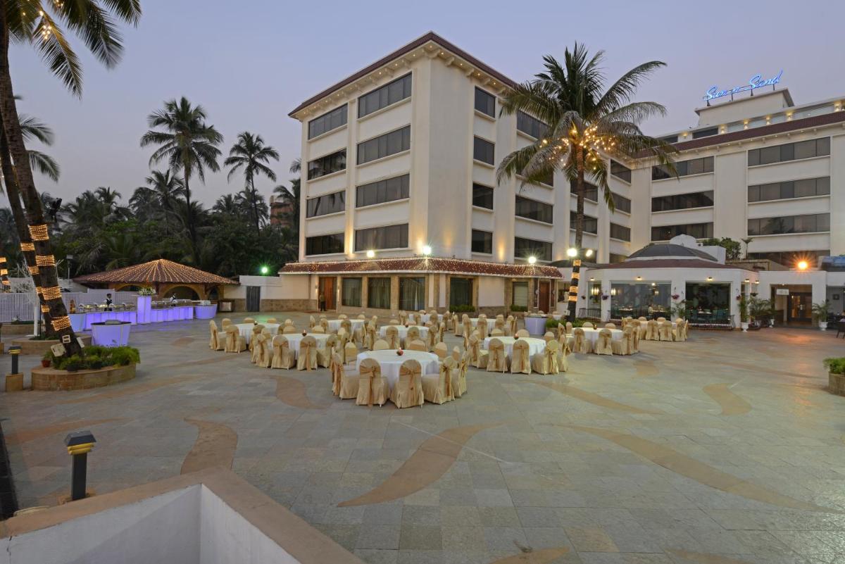 a group of tables and chairs in front of a building at Sun-n-Sand Mumbai Juhu Beach in Mumbai