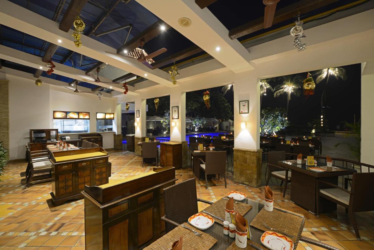 a restaurant with tables and chairs and a bar at Sun-n-Sand Mumbai Juhu Beach in Mumbai