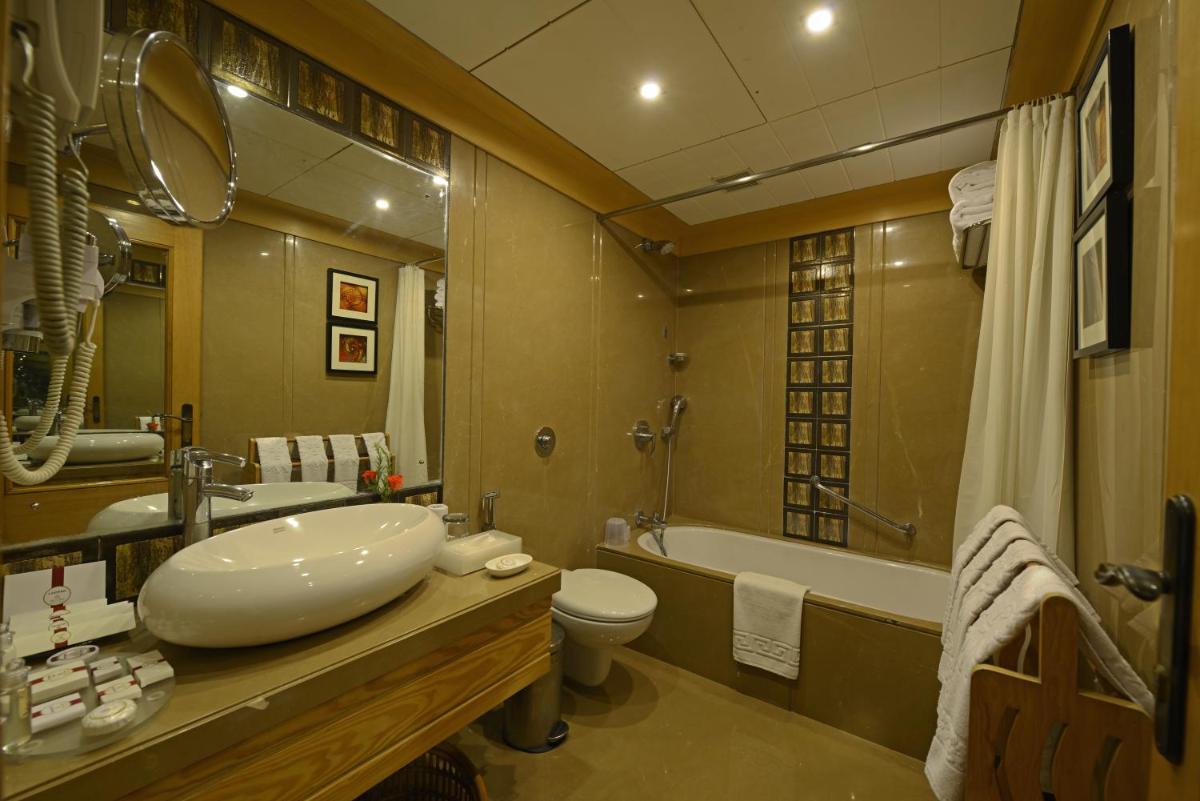 a bathroom with a sink and a toilet and a tub at Sun-n-Sand Mumbai Juhu Beach in Mumbai