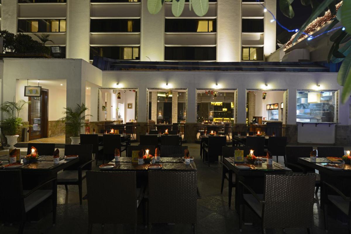 a restaurant with tables and chairs in front of a building at Sun-n-Sand Mumbai Juhu Beach in Mumbai