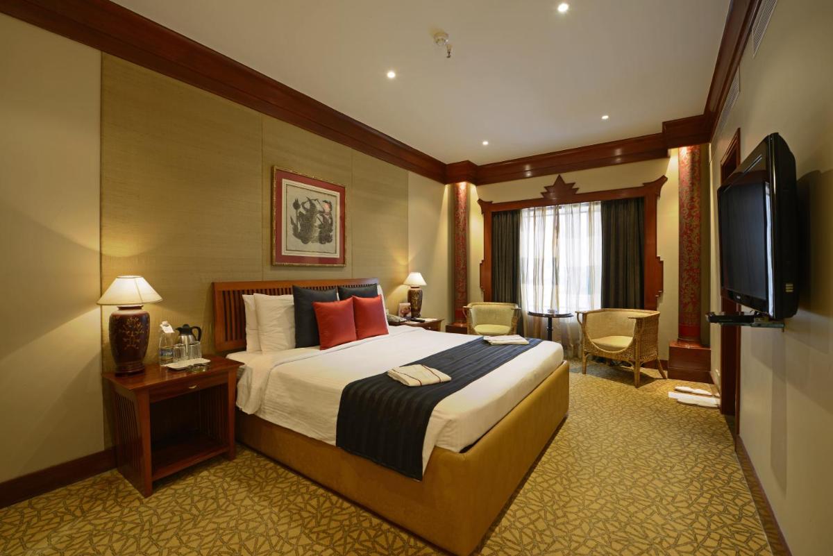 a hotel room with a bed and a television at Sun-n-Sand Mumbai Juhu Beach in Mumbai