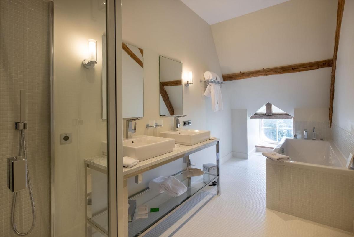 une salle de bain avec deux lavabos et une douche dans l'établissement La Borde en Sologne Château & Spa, à Vernou-en-Sologne