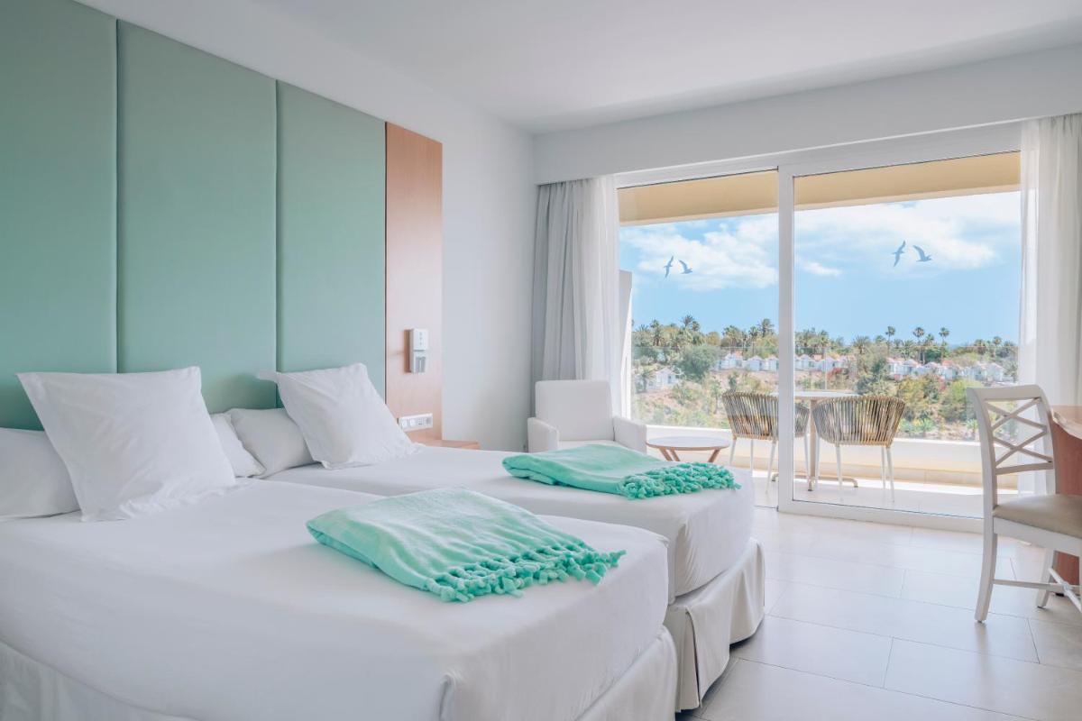 Dos camas blancas en una habitación con vista al mar. en Iberostar Waves Playa Gaviotas All Inclusive, en Morro del Jable