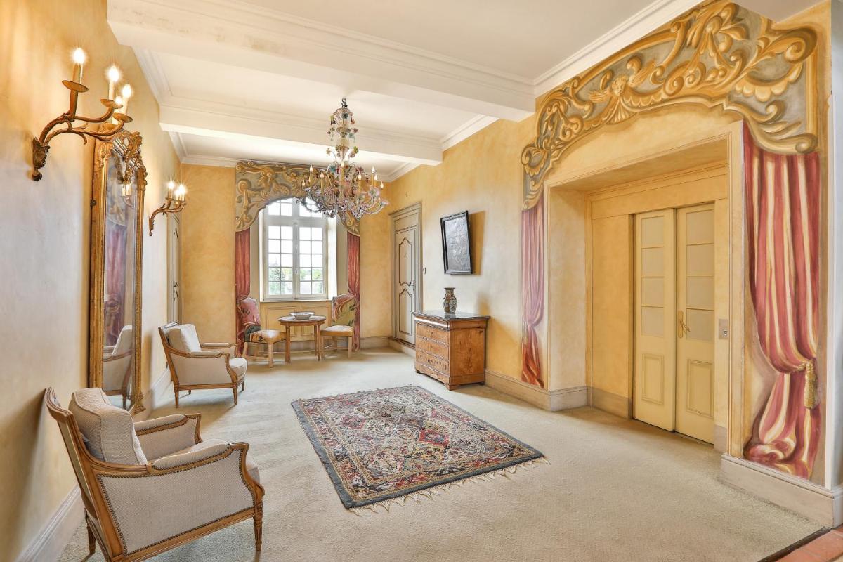 une grande pièce avec une porte, une table et des chaises dans l'établissement Château des Vigiers, à Monestier