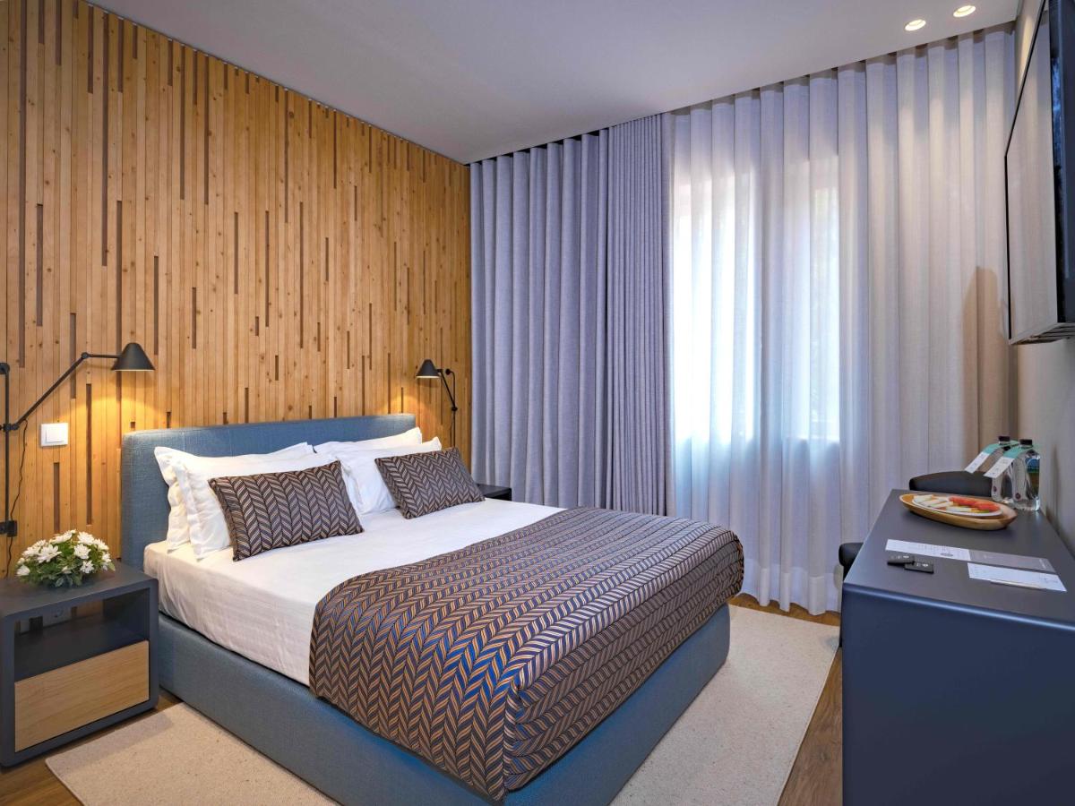 um quarto com uma cama e uma escrivaninha com uma televisão em Central Monchique Hotel - Villa Termal Spa Resort - by Unlock Hotels em Monchique