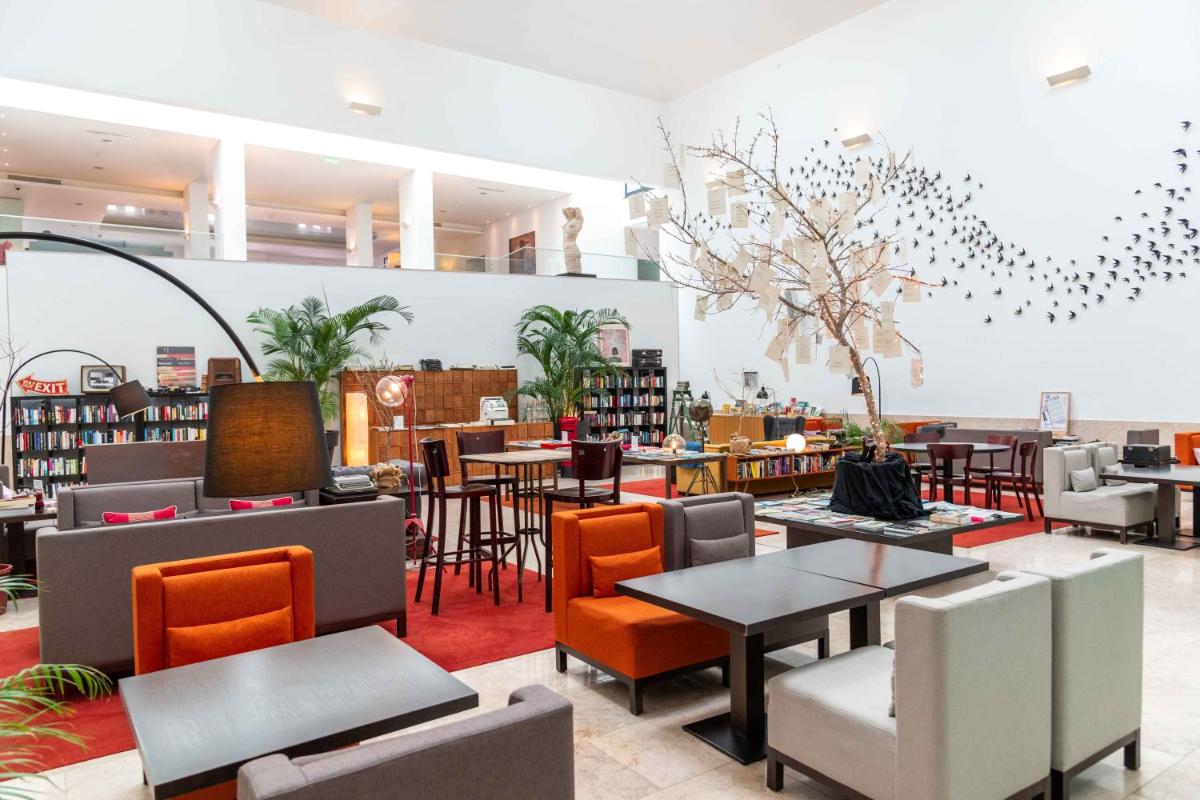 uma livraria com mesas e cadeiras em uma biblioteca em Pestana Cidadela Cascais - Pousada & Art District em Cascais