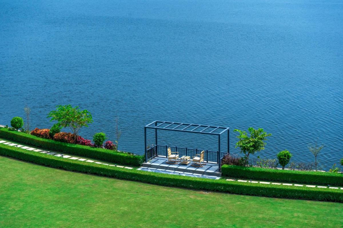 a gazebo sitting on the side of the water at ZANA Lakeview Resort - most scenic lakeside resort in Udaipur