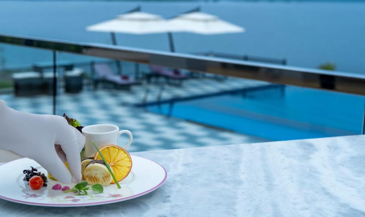 a plate of food on a table next to a pool at ZANA Lakeview Resort - most scenic lakeside resort in Udaipur