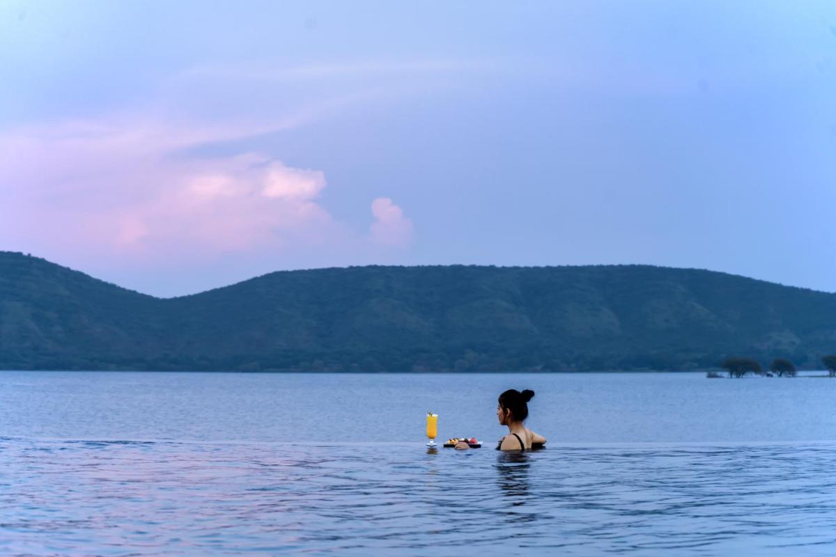 a woman standing in a body of water at ZANA Lakeview Resort - most scenic lakeside resort in Udaipur