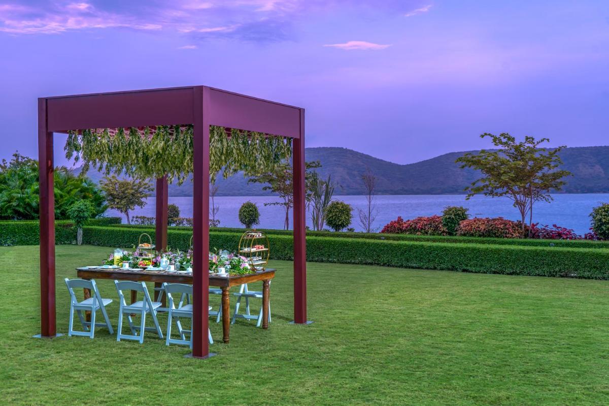 a table with chairs and a purple gazebo at ZANA Lakeview Resort - most scenic lakeside resort in Udaipur