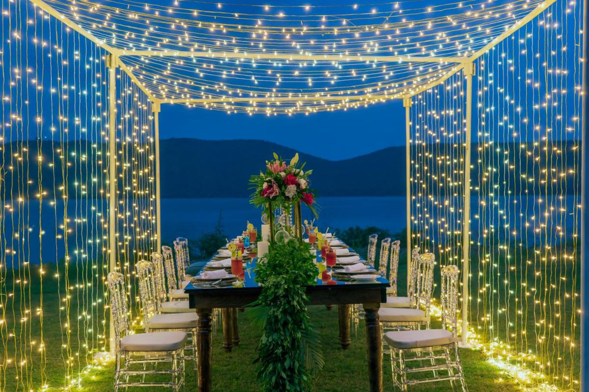 a long table with white chairs and lights at ZANA Lakeview Resort - most scenic lakeside resort in Udaipur