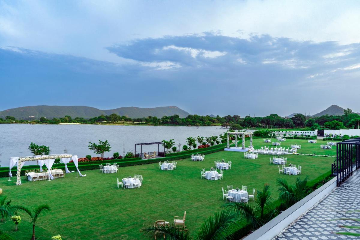 a wedding reception on the lawn next to the water at ZANA Lakeview Resort - most scenic lakeside resort in Udaipur