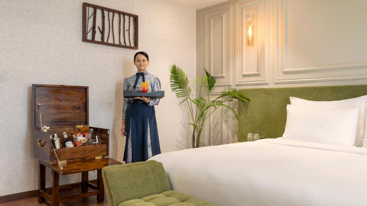 a woman standing in a room with a bed at ZANA Lakeview Resort - most scenic lakeside resort in Udaipur