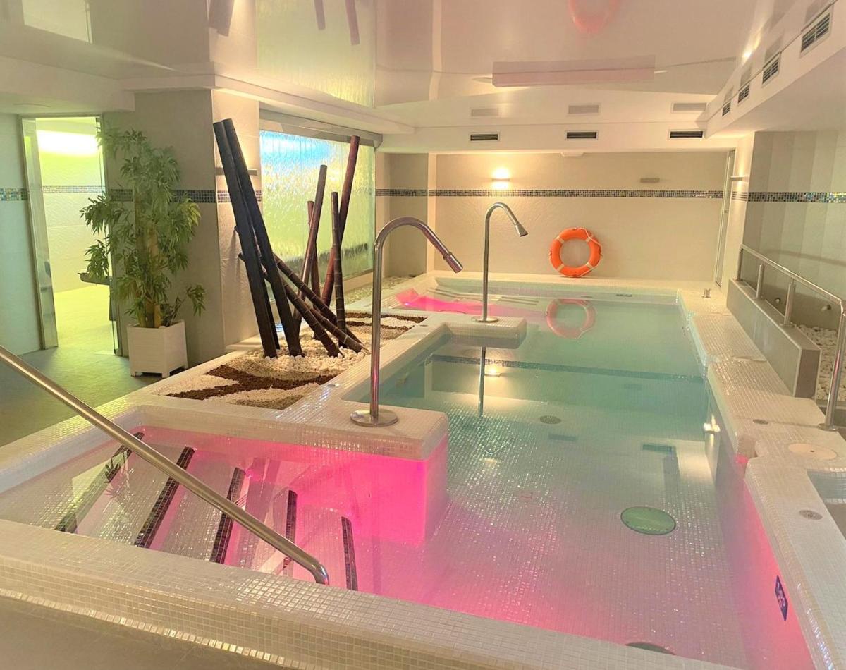 Un jacuzzi en una habitación con agua rosada. en Hotel Playamar Spa, en Laredo