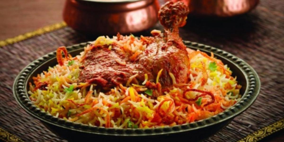 a bowl of food with meat and rice on a table at Crowne Plaza New Delhi Okhla by IHG in New Delhi
