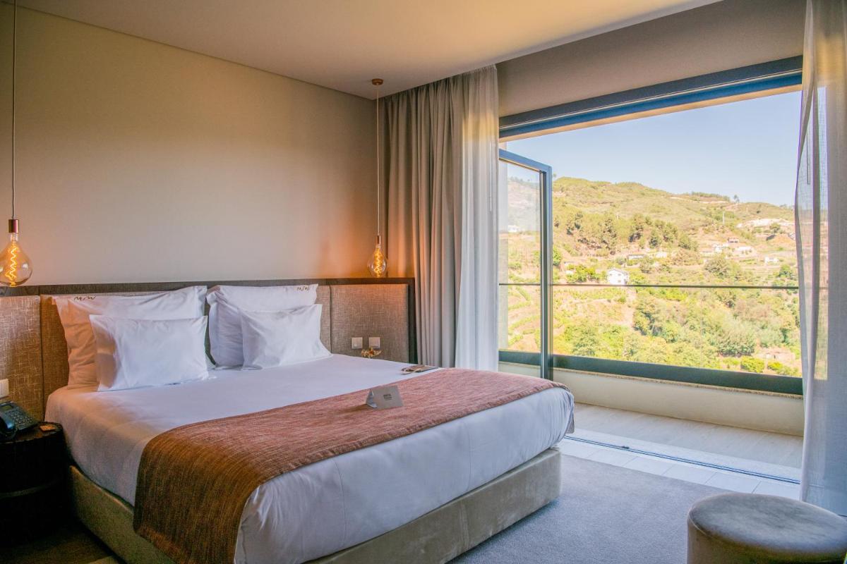 um quarto de hotel com uma cama e uma janela grande em MW Douro Wine & Spa em Santa Marta de Penaguião mais 82 fotografias