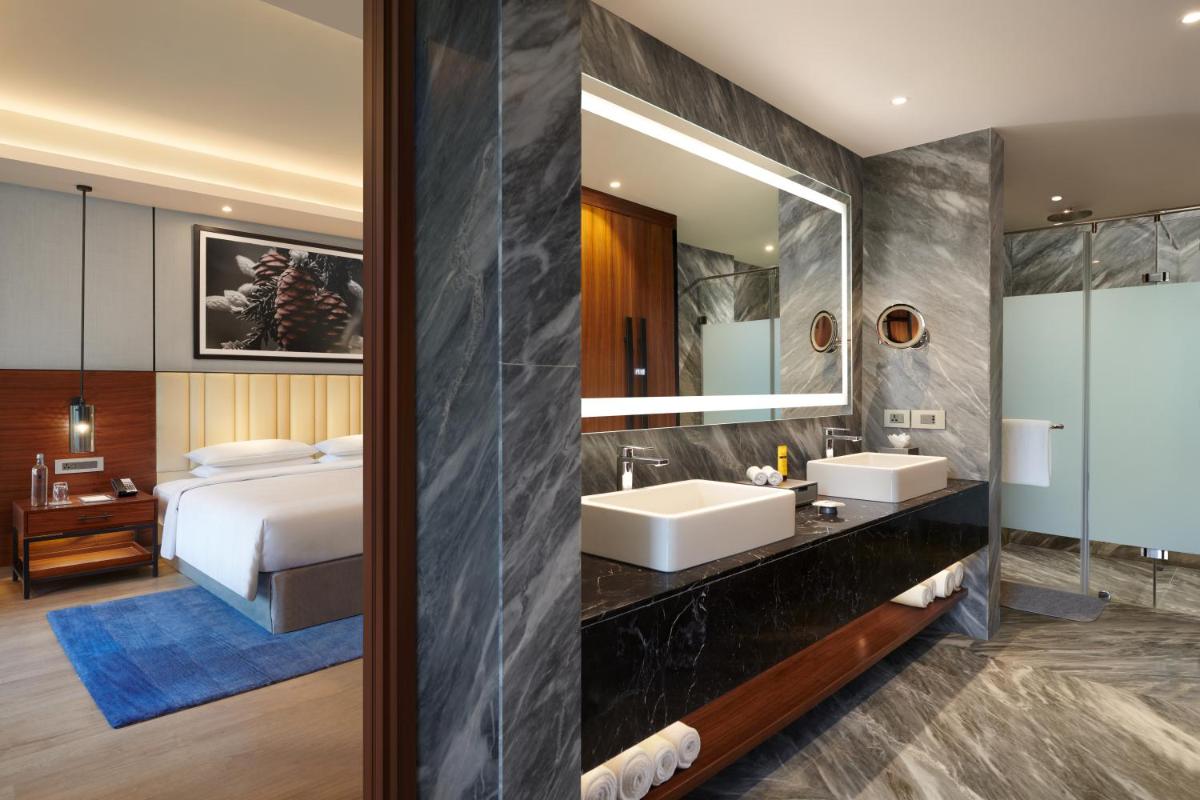 a hotel room with two sinks and a bed at Hyatt Regency Dehradun Resort and Spa in Dehradun