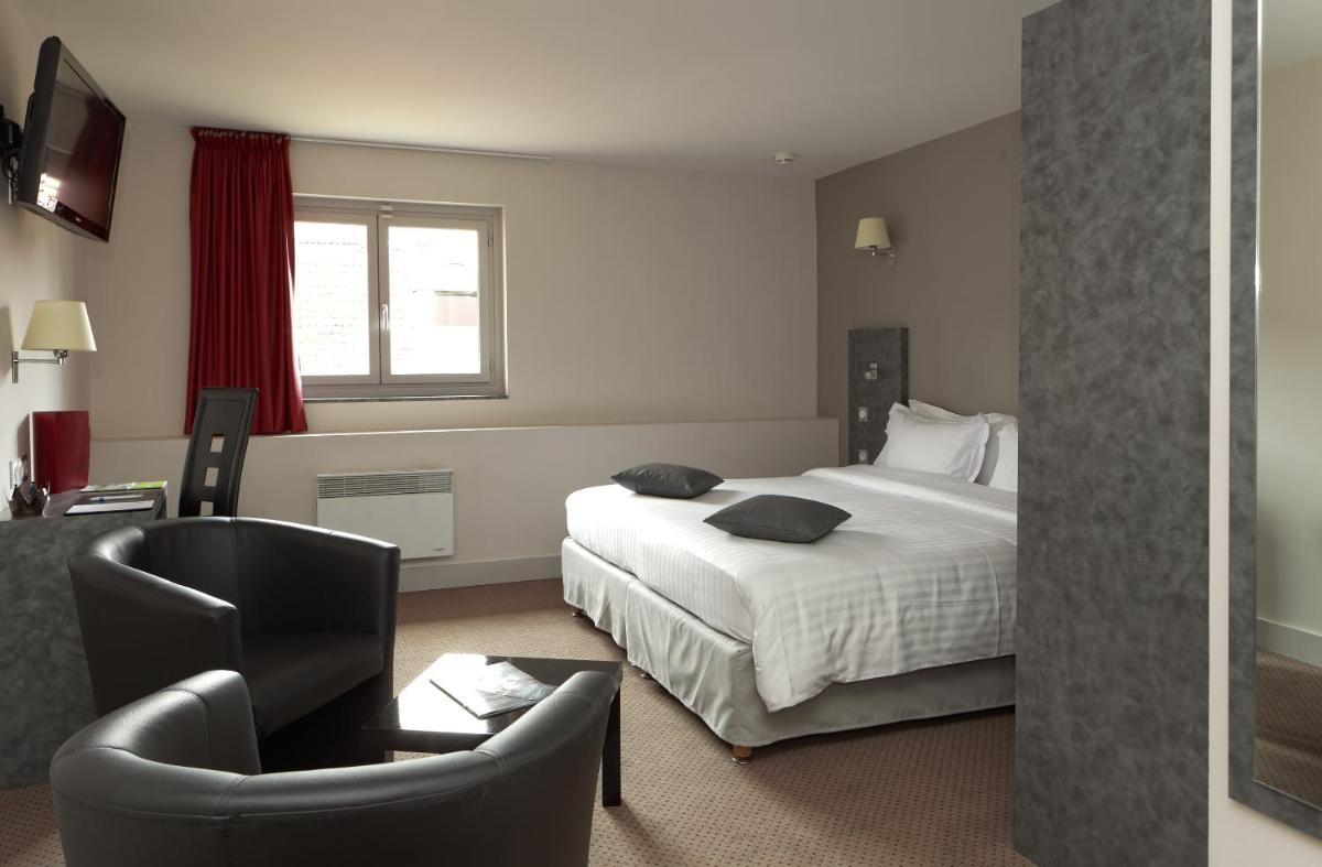 une chambre d'hôtel avec un lit et une chaise dans l'établissement La Table de Gustave, à Ornans