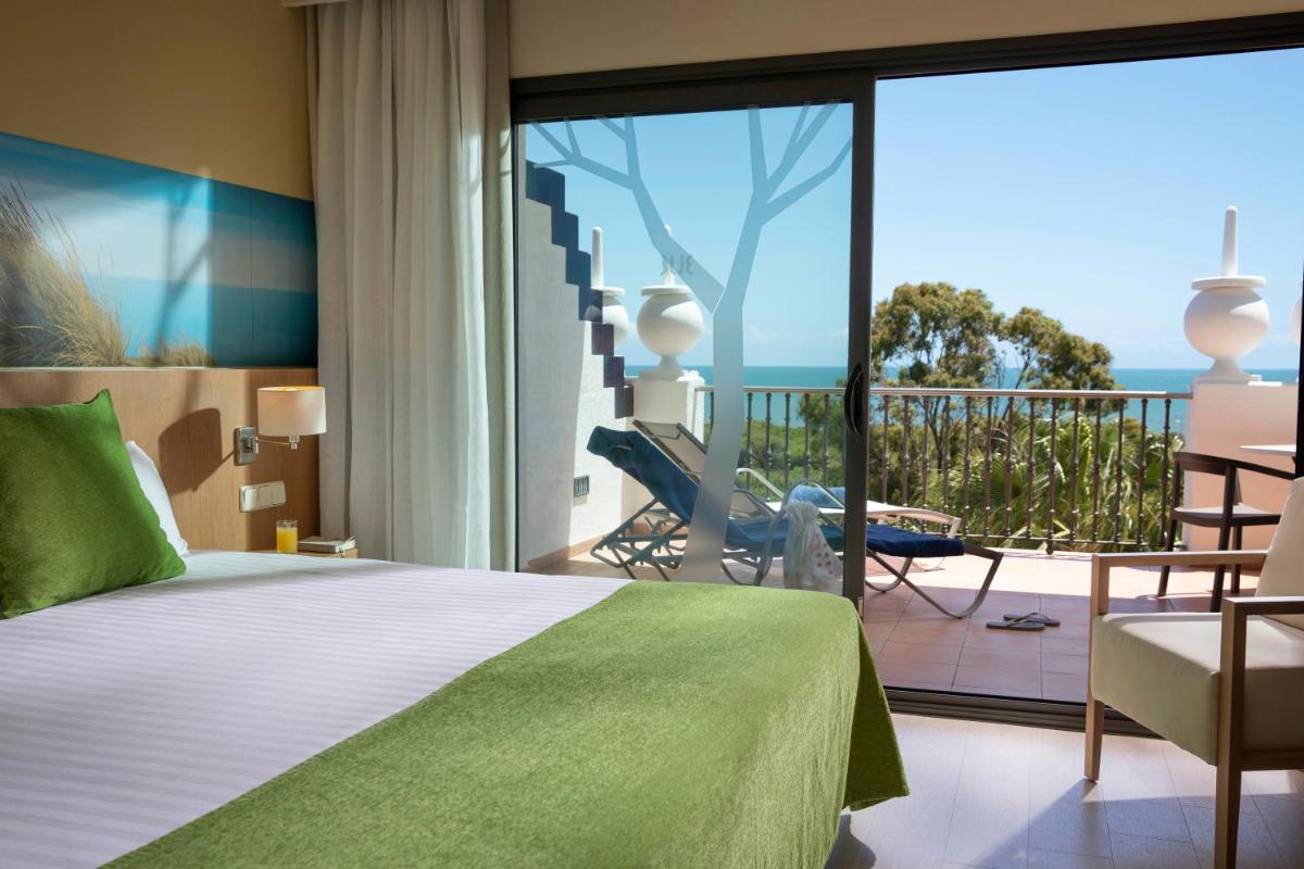Un dormitorio con una cama y un balcón con vista al mar. en TUI Blue Isla Cristina Palace - Adults Recommended, en Isla Cristina