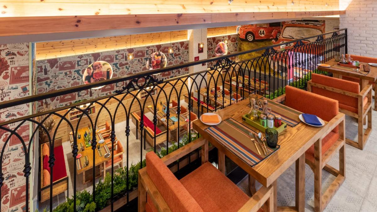 a restaurant with a fence and a table and chairs at Holiday Inn New Delhi Aerocity by IHG in New Delhi