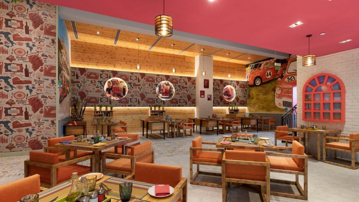 a restaurant with wooden tables and chairs and red ceilings at Holiday Inn New Delhi Aerocity by IHG in New Delhi