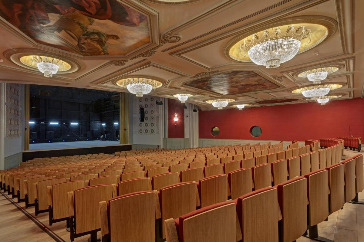 un auditorio vacío con sillas y lámparas de araña en UMusic Hotel Madrid, en Madrid