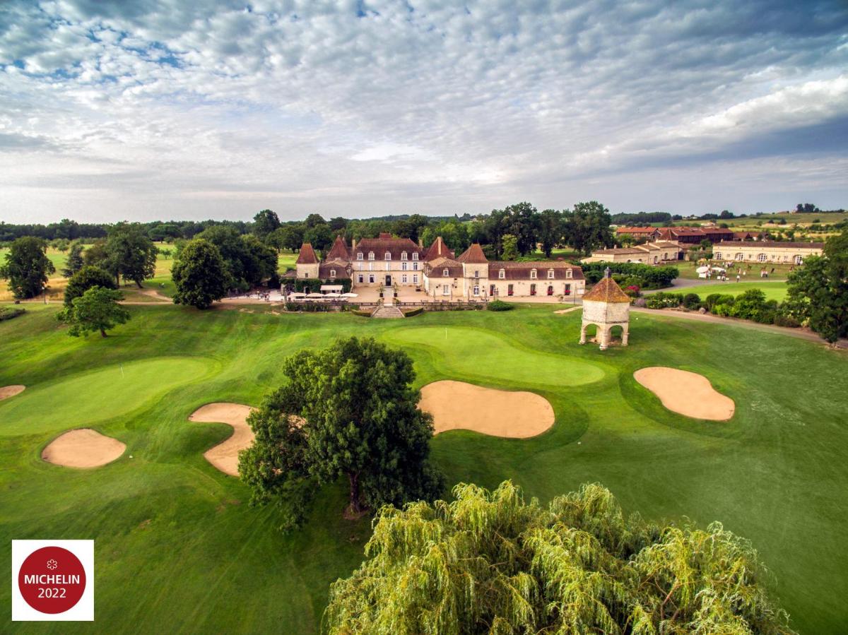 une vue aérienne d'un terrain de golf avec un bâtiment dans l'établissement Château des Vigiers, à Monestier