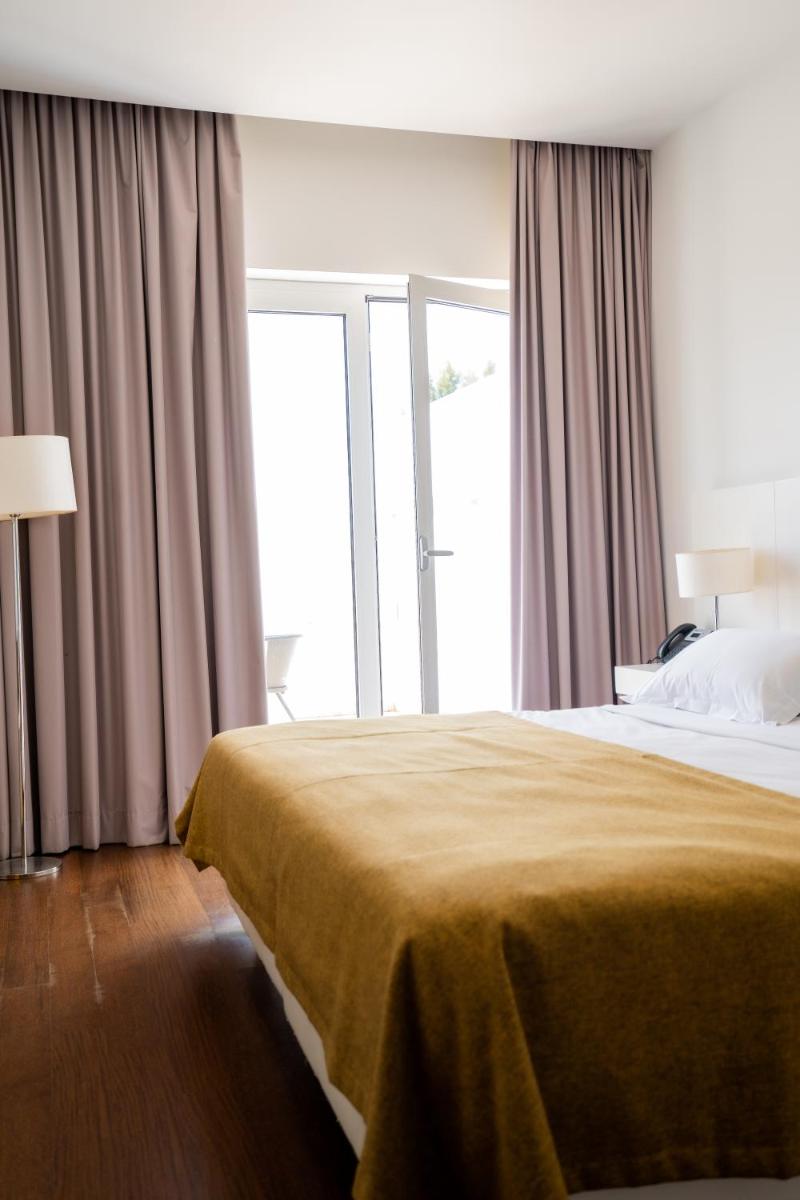 Uma cama ou camas num quarto em Hotel Vila D'Óbidos