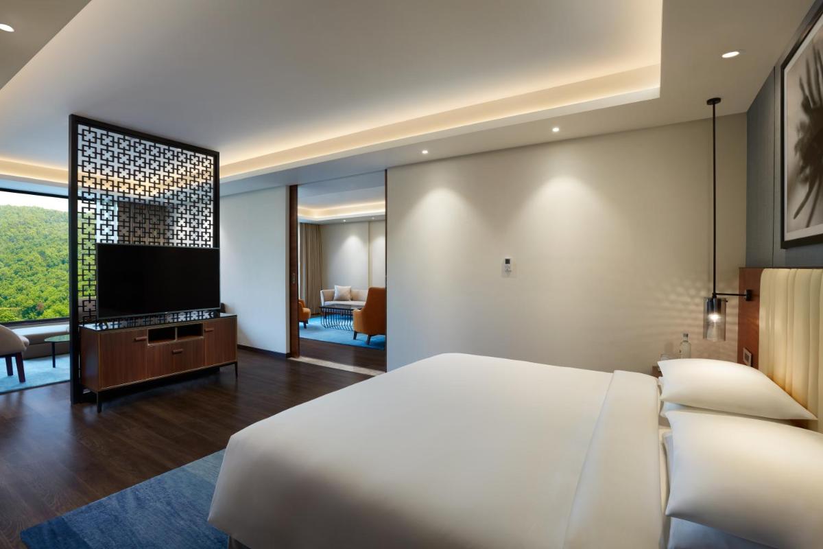 a bedroom with a bed and a flat screen tv at Hyatt Regency Dehradun Resort and Spa in Dehradun