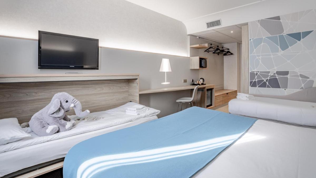 Un ou plusieurs lits dans un hébergement de l'établissement Hotel Plaza - site du Futuroscope