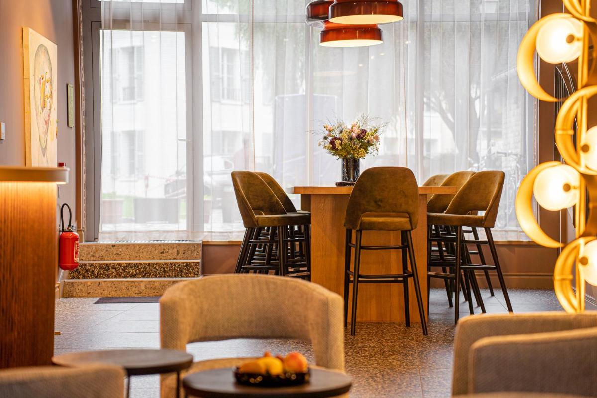 une salle d'attente avec des chaises et une table avec dans l'établissement L'INVITATION AU VOYAGE - Hôtel & Spa, à Honfleur