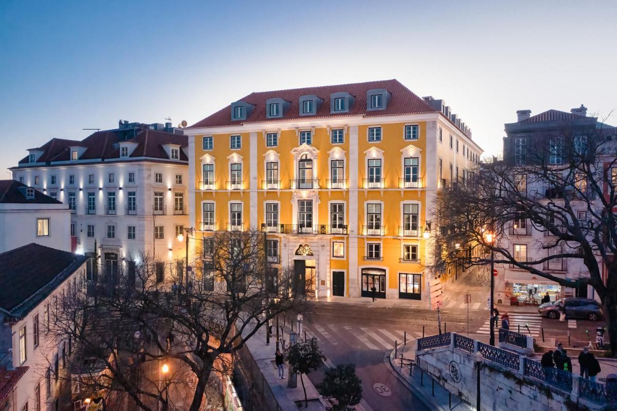 um edifício amarelo no meio de uma rua em Palácio Ludovice Wine Experience Hotel em Lisboa