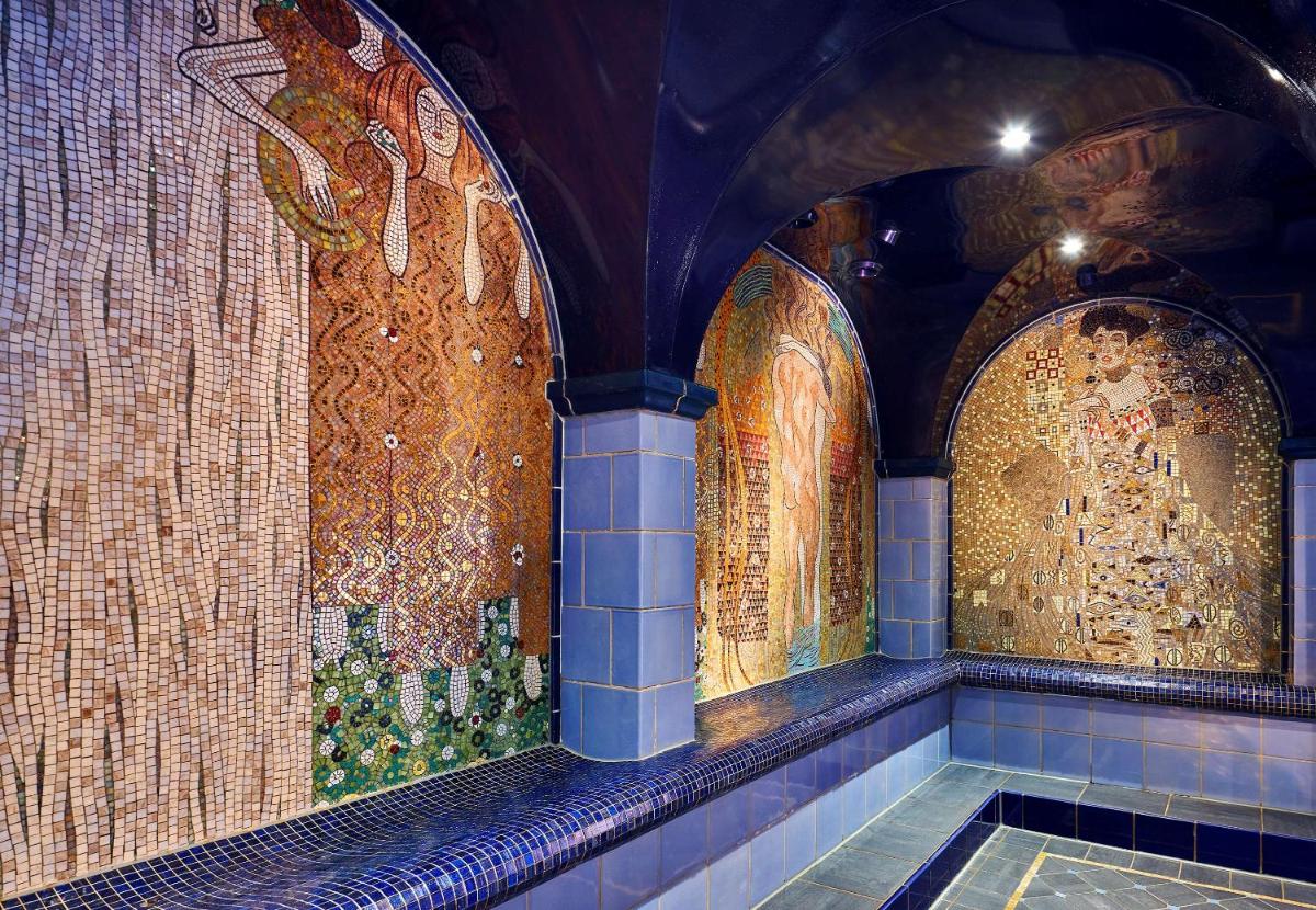 ein Badezimmer mit Mosaiken an den Wänden eines Gebäudes in der Unterkunft Maison Messmer - ein Mitglied der Hommage Luxury Hotels Collection in Baden-Baden + 75 Fotos