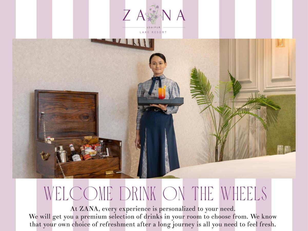 a woman holding a tray with a drink on it at ZANA Lakeview Resort - most scenic lakeside resort in Udaipur