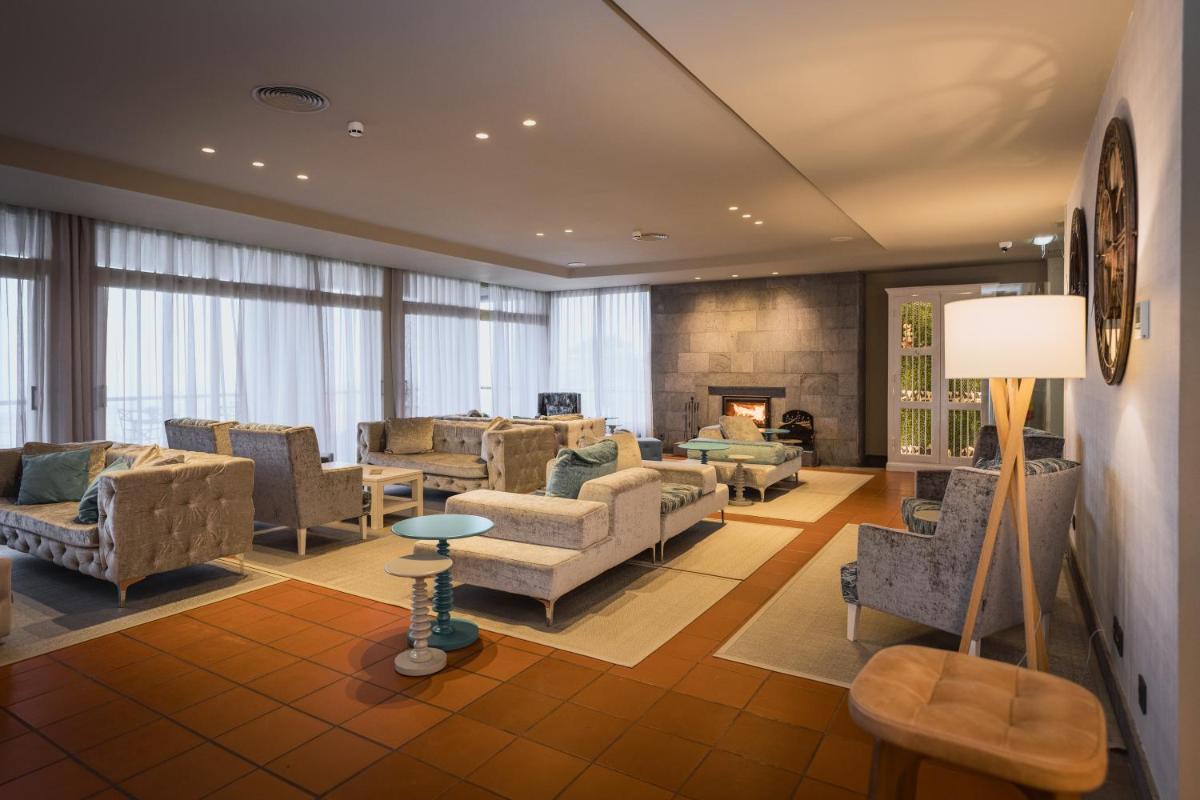 uma sala de estar com sofás e cadeiras e uma lareira em The Lince Nordeste em Nordeste