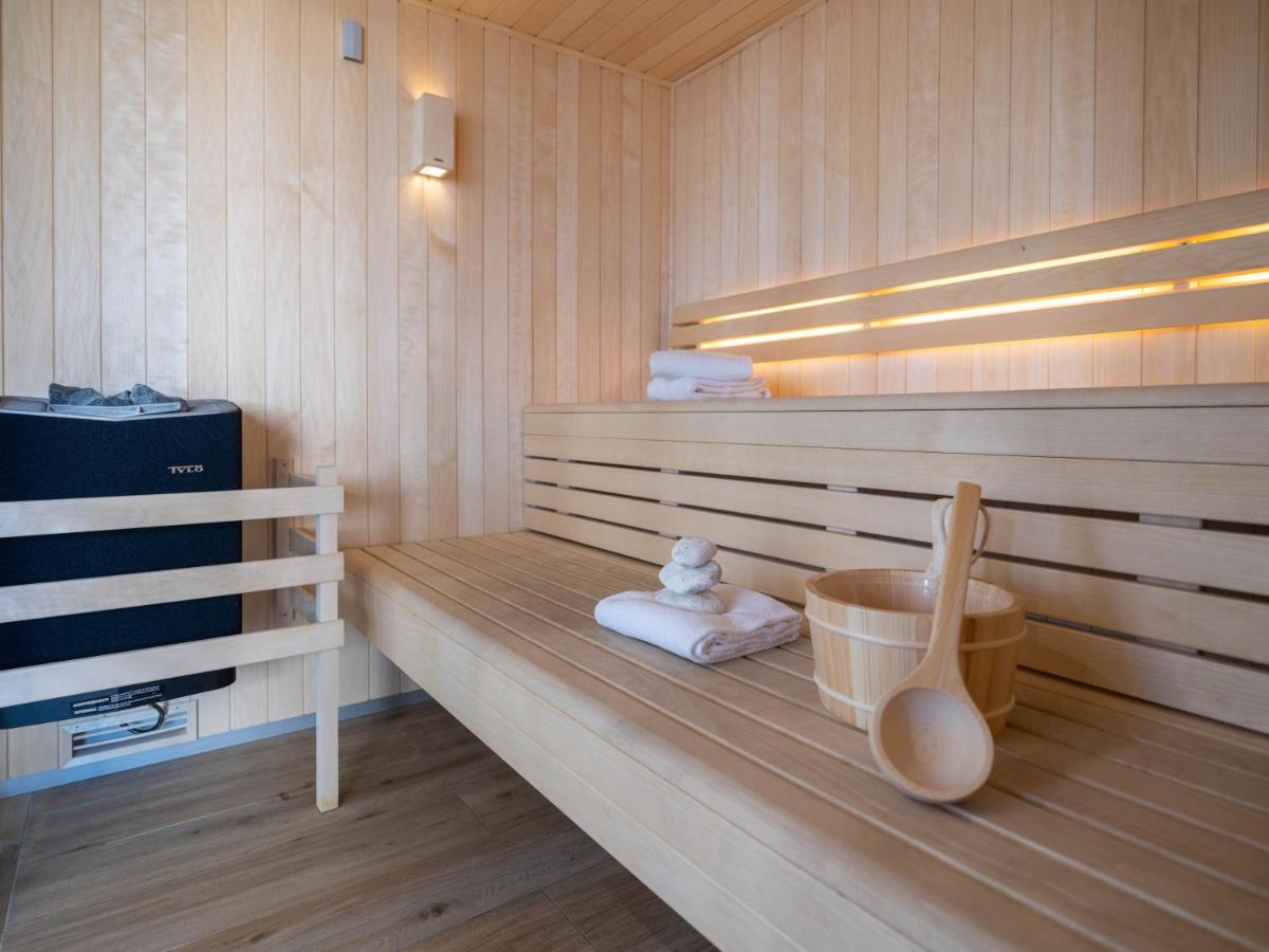 un sauna avec un banc en bois avec des serviettes dessus dans l'établissement Westotel Pornic Côte de Jade, à Pornic
