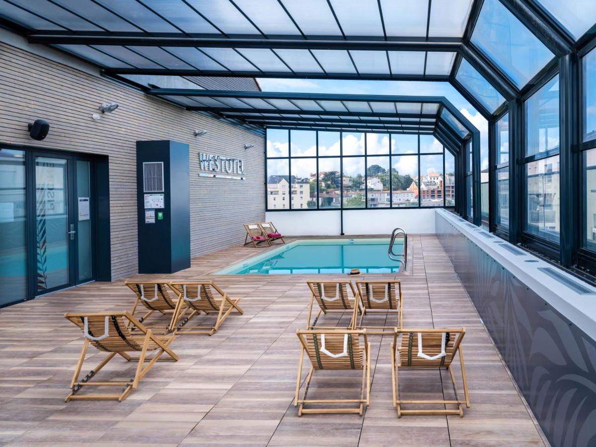 - une piscine intérieure avec des chaises et une table dans l'établissement Westotel Pornic Côte de Jade, à Pornic