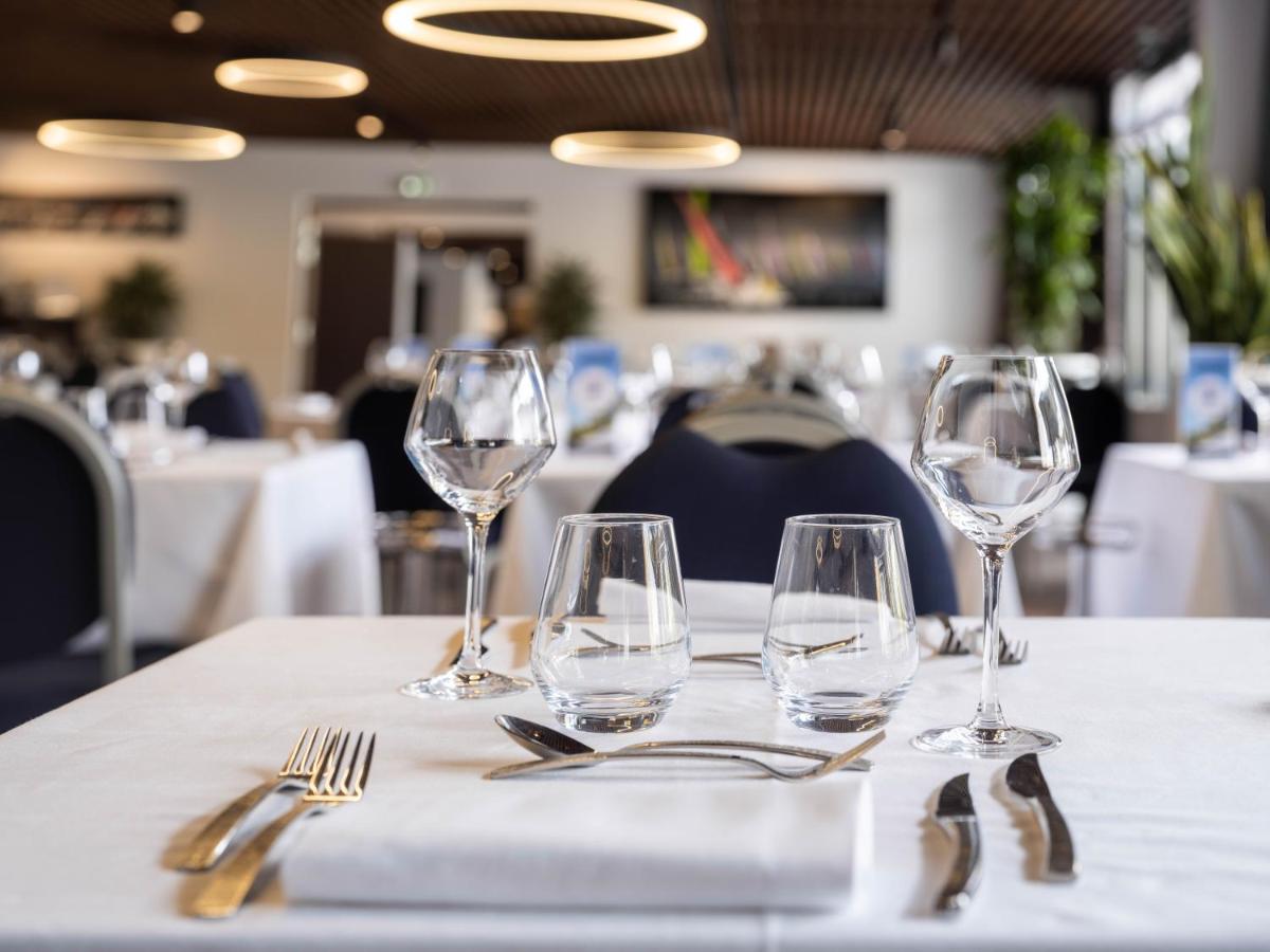- une table avec quatre verres à vin et de l'argenterie dans l'établissement Westotel Pornic Côte de Jade, à Pornic