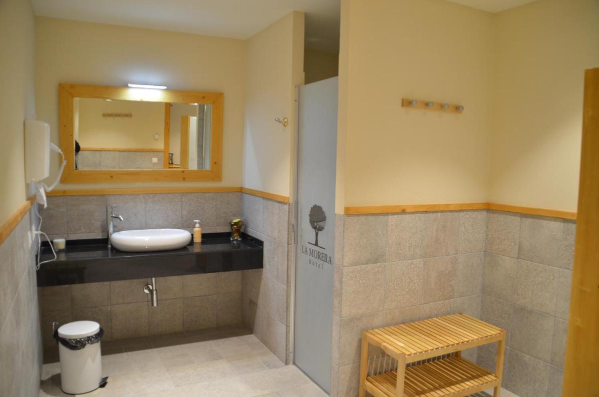 un baño con lavabo y espejo en Hotel La Morera, en Valencia de Aneu