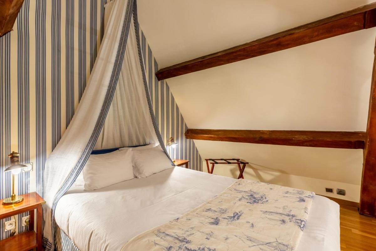 Un ou plusieurs lits dans un hébergement de l'établissement Demeures & Châteaux Hôtel Domaine le Clos des Fontaines