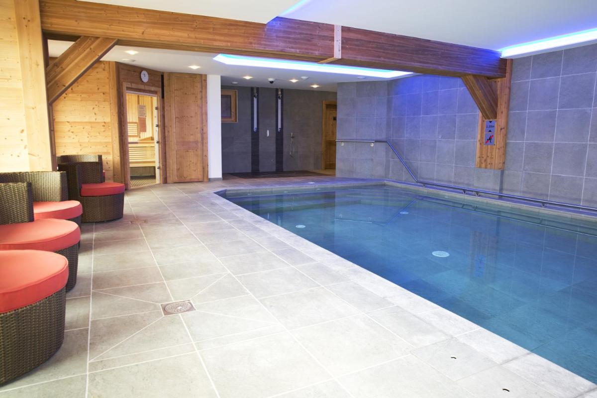 une grande piscine dans un immeuble avec dans l'établissement Les Chalets de La Griyotire, à Praz-sur-Arly