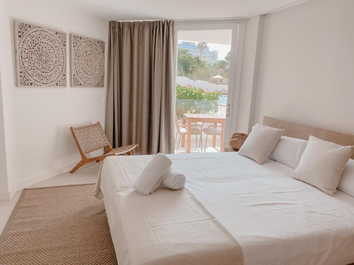 Un dormitorio con una gran cama blanca con ventana. en Portomar Apartments - 4-Star Superior Hotel, en Portocolom