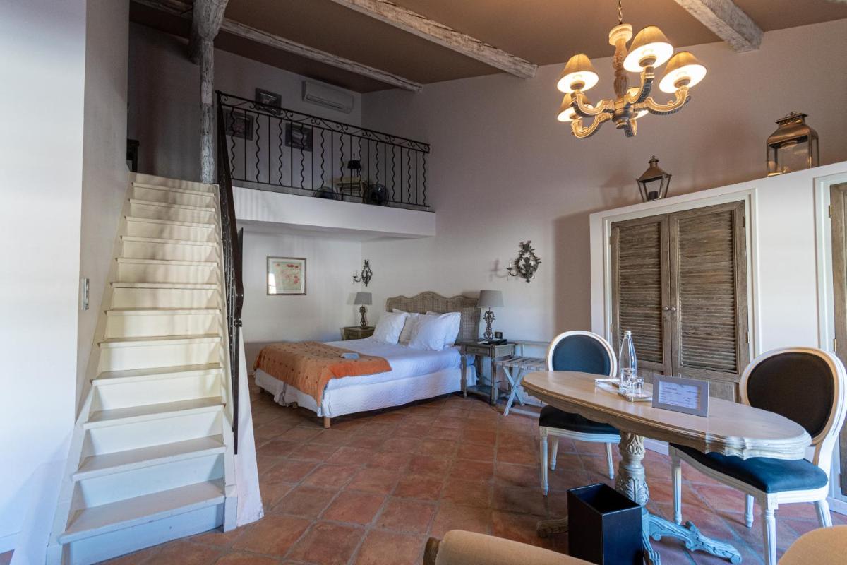 - une chambre avec un lit, un escalier et une table dans l'établissement Le Domaine Du Colombier, à Malataverne
