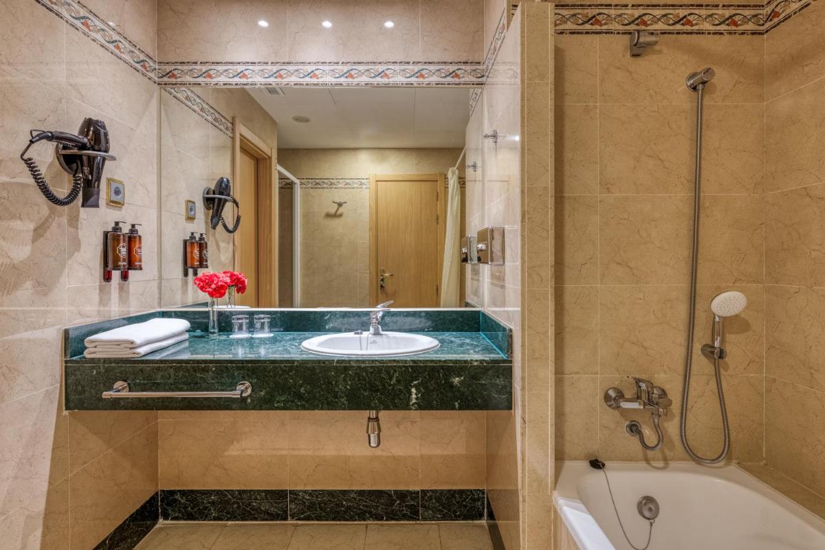 Un baño con lavabo, bañera y ducha. en Playacartaya, en El Portil