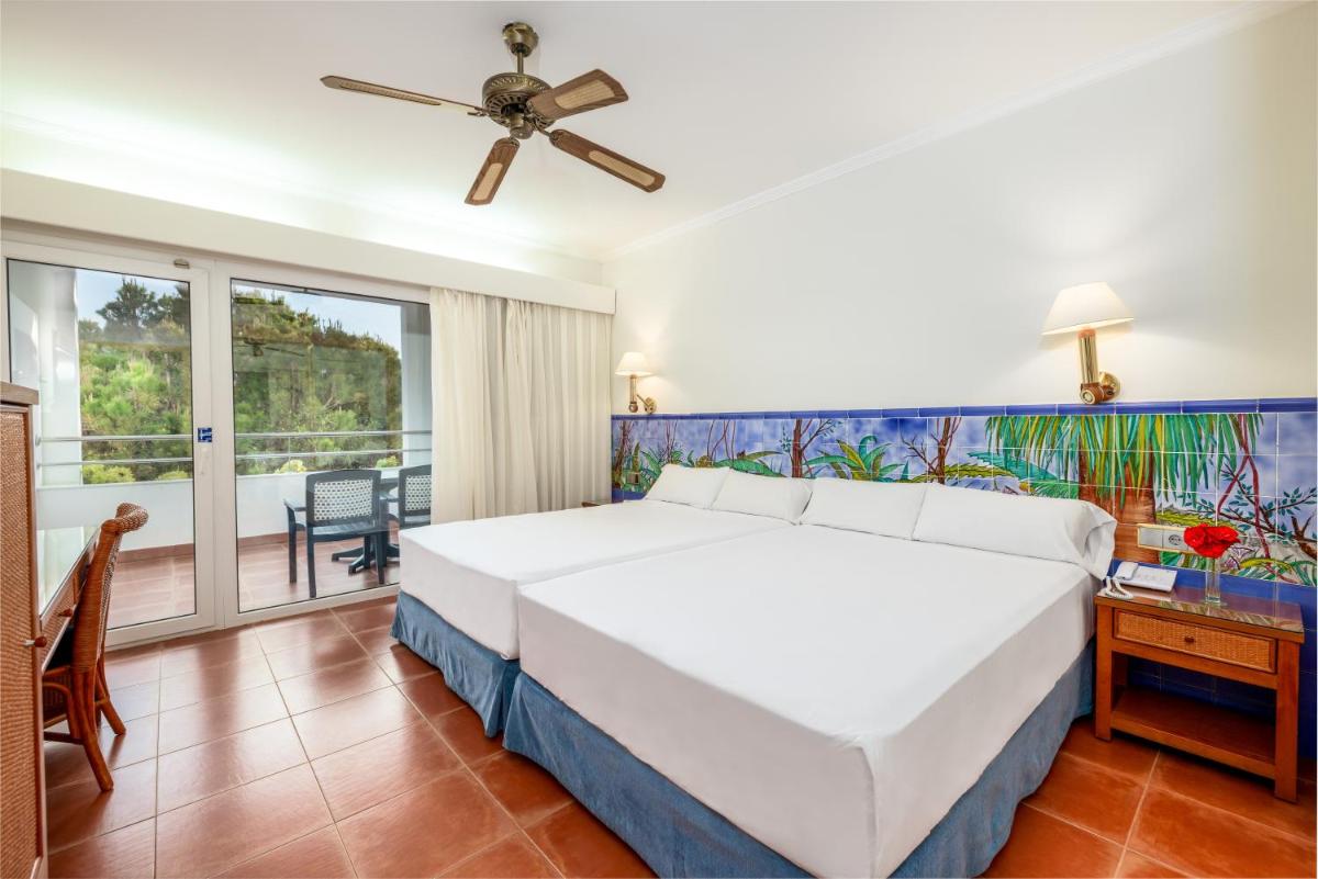 Un dormitorio con una gran cama blanca y un balcón. en Playacartaya, en El Portil
